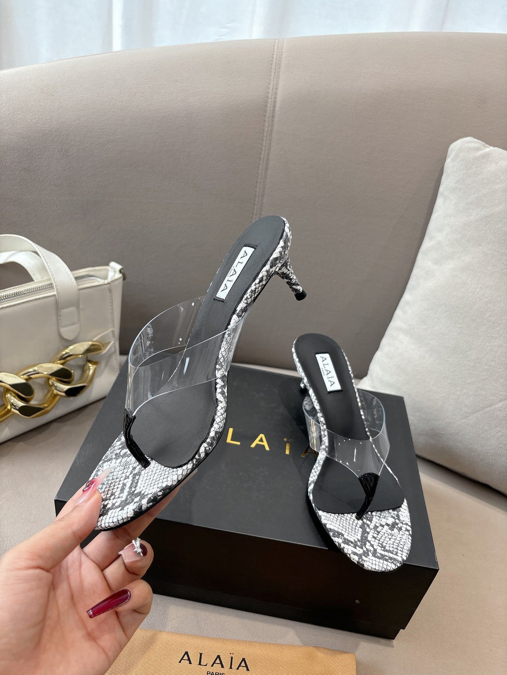 ALAIA HEELED THONG 25S 55 MM IN WHITE AND BLACK LAMBSKIN SNAKE-EMBOSSED WITH CLEAR STRAP
